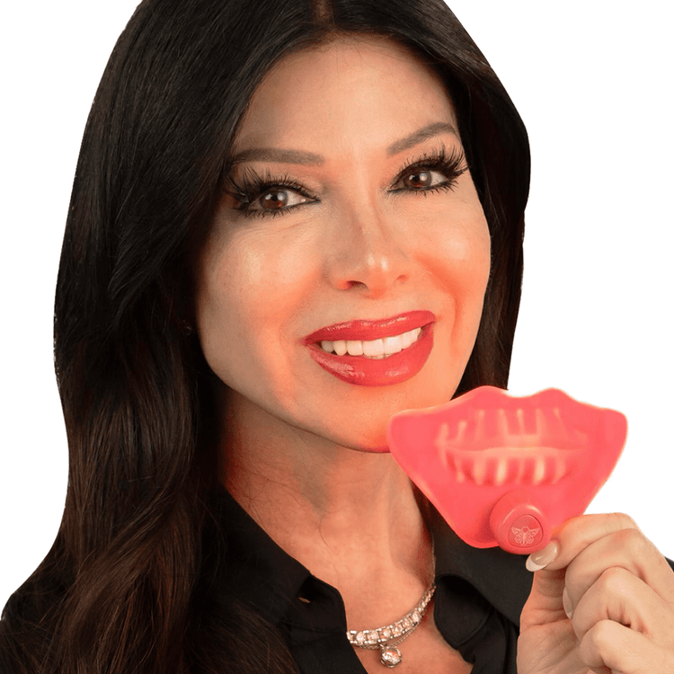 Woman holding dental appliance, smiling with white teeth.