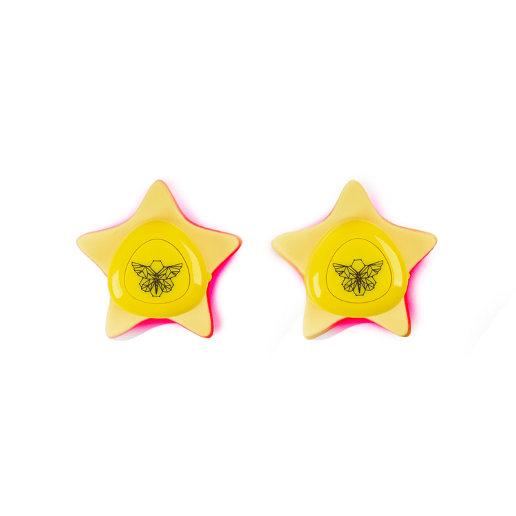 Two yellow star-shaped Metamorphosis SuperStar Pimple Patches, which are FDA 510(k)-cleared portable LED light therapy devices designed to target acne, reduce inflammation, and kill bacteria