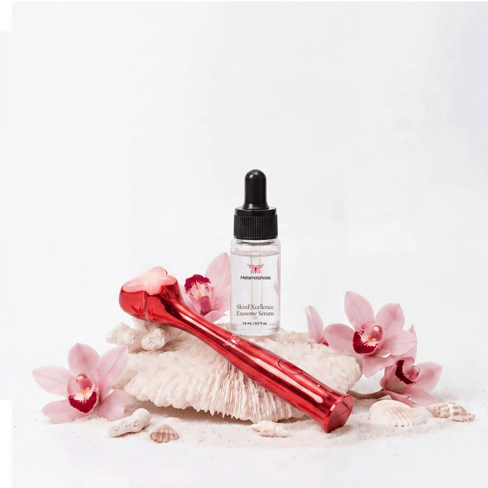 Metamorphosis RubyRadiance Ultimate Glow Kit featuring the red light therapy wand and SkinEXcellence Exosome Serum on white coral.