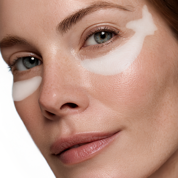 Sequence showing the placement of a white butterfly-shaped hydrogel mask on the under-eye area for targeted skincare treatment.