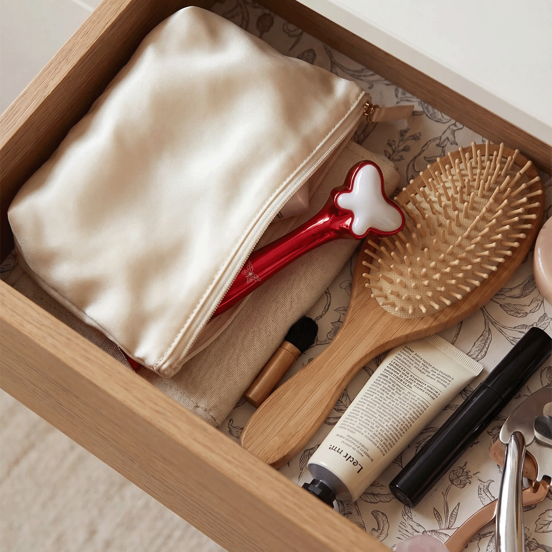Metamorphosis Cosmetic items including a hairbrush, tube of cream, and makeup brush in an open drawer.