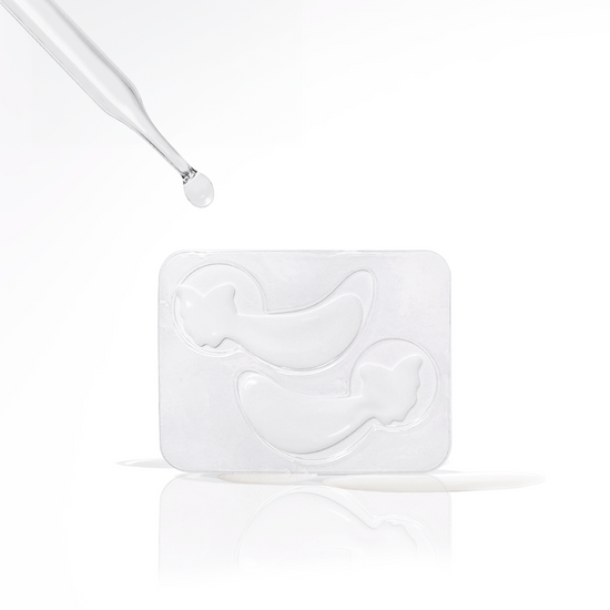 Metamorphosis A clear dropper dispensing a drop of serum over two white eye masks in a plastic tray, illustrating the application method for eye masks.