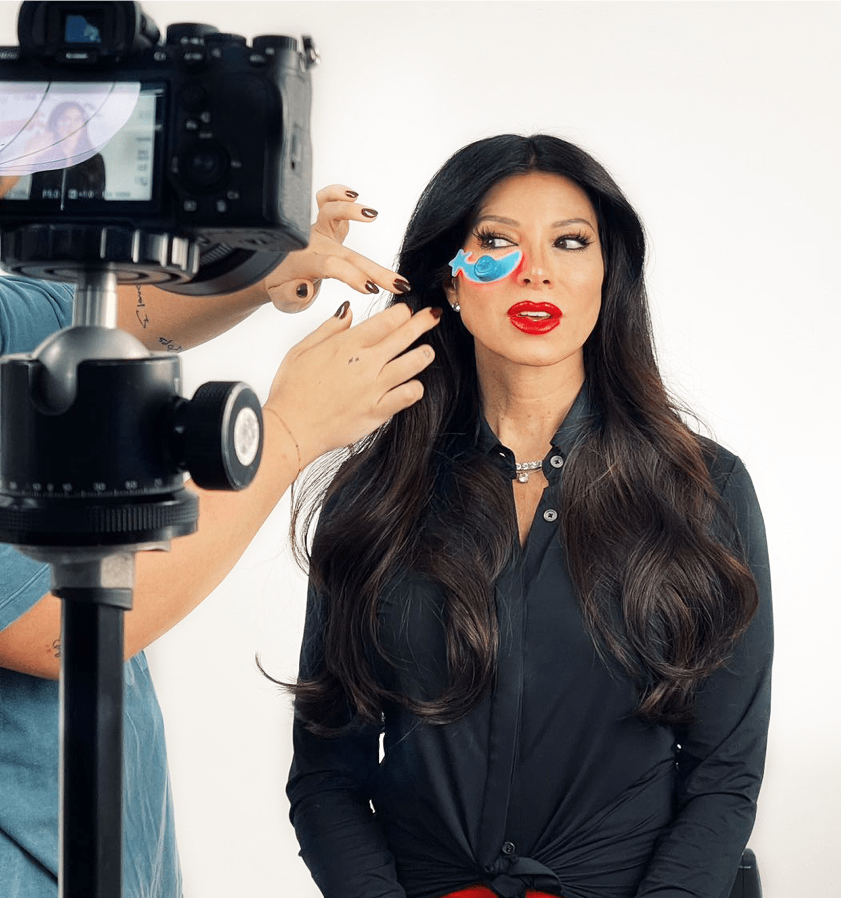 The founder of Metamorphosis Sally Gardocki, during a photoshoot, wearing red lipstick and a blue butterfly eye patch, accompanying text that reads 'FOUNDER'S STORY'