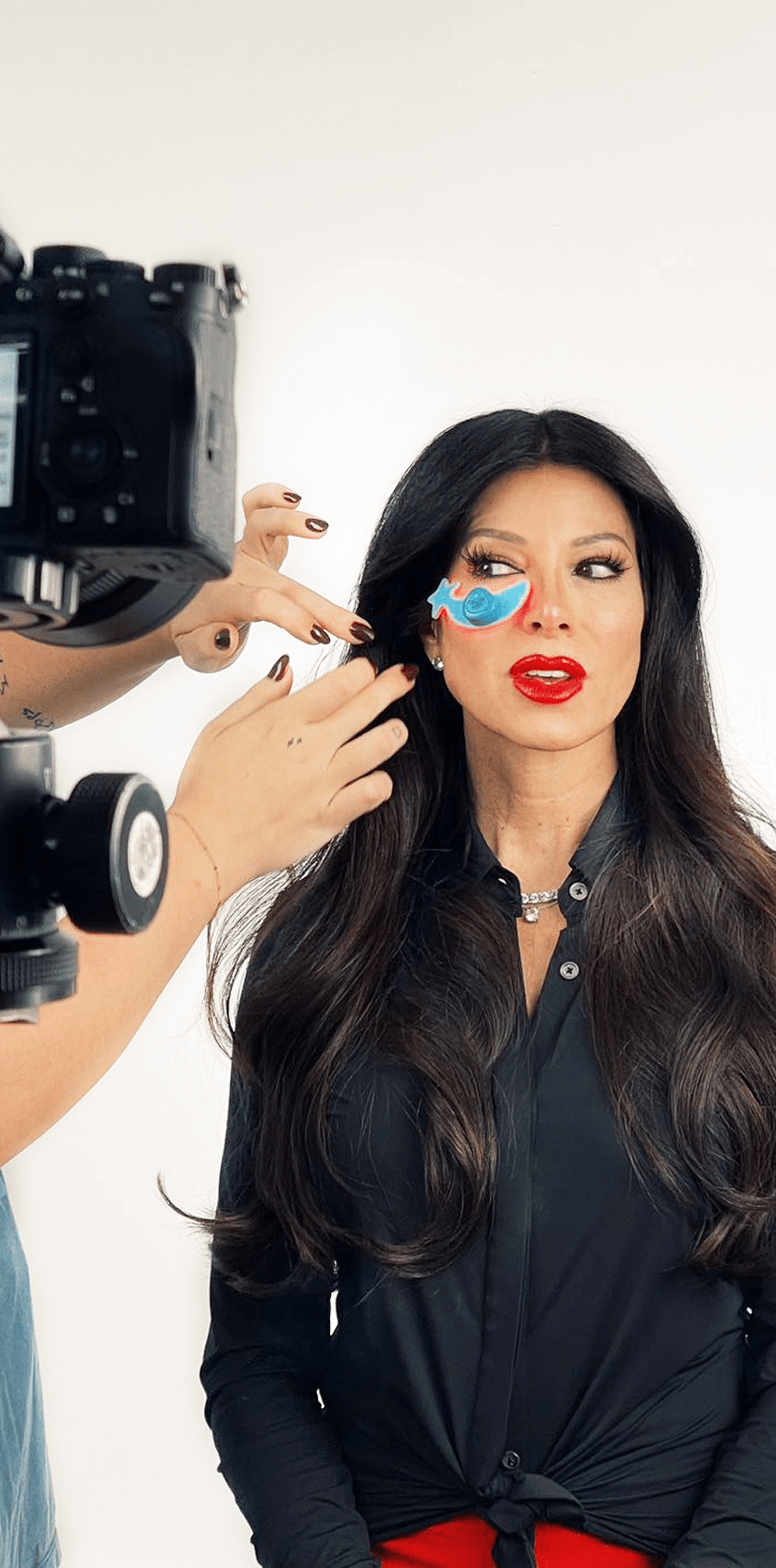 The founder of Metamorphosis Sally Gardock during a photoshoot, wearing red lipstick and a blue butterfly eye patch, accompanying text that reads 'FOUNDER'S STORY'
