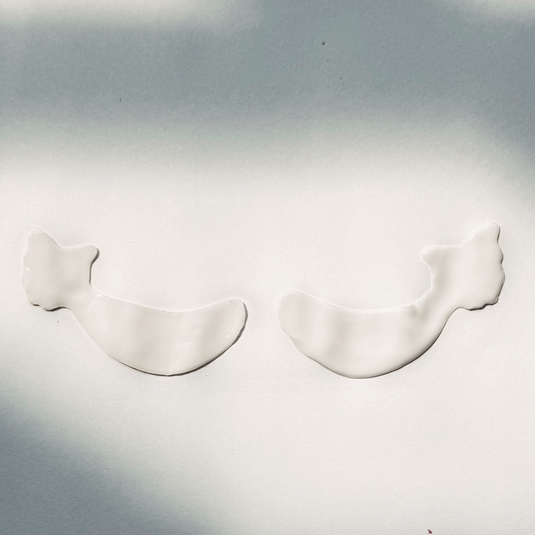 Two white, wing-shaped Metamorphosis Absorbable Bio-Collagen Eye Masks on a white background, highlighting the physical appearance of the eye patches for under-eye recovery and hydration.